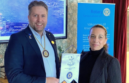 Presidenten Lars Kylin välkomnar Cecilia Engsborn till klubben med att överlämna Knivsta Rotaryklubbs standar.